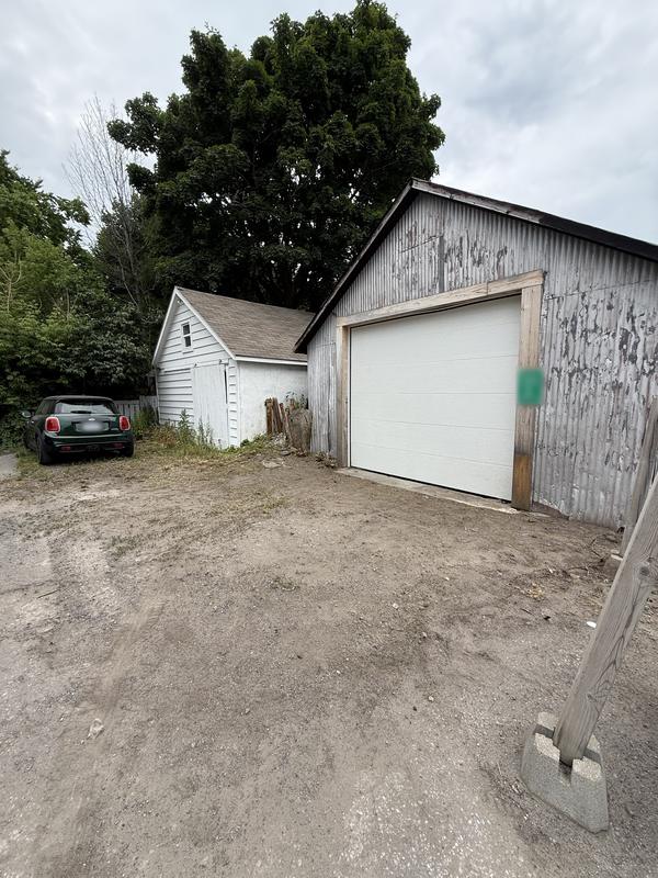 After: The same garage with the overgrowth cleared back to a clean lot