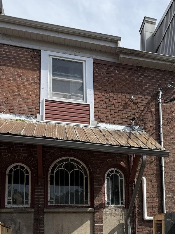 After: The same brick wall with the vines removed and the windows uncovered